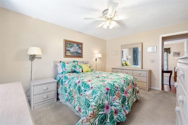 bedroom featuring a ceiling fan, a textured ceiling, and light colored carpet