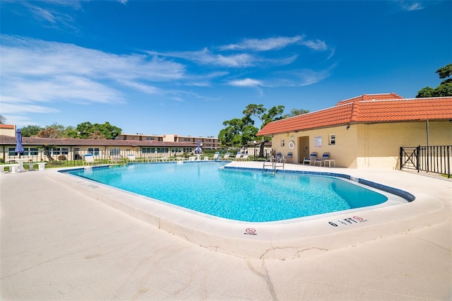 community pool featuring fence and a patio