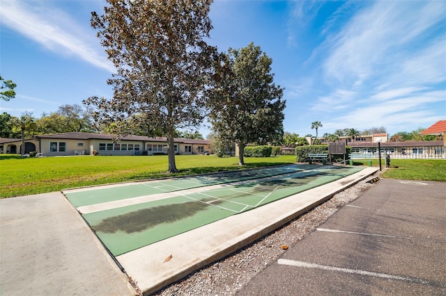 view of community featuring shuffleboard and a yard