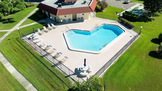 community pool featuring a patio, a yard, and fence