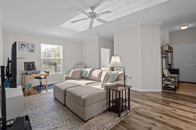 living room with ornamental molding, ceiling fan, baseboards, and wood finished floors