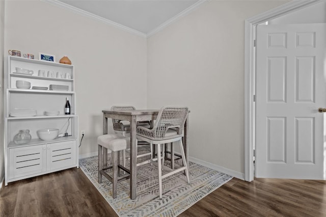 dining area with crown molding, baseboards, and wood finished floors