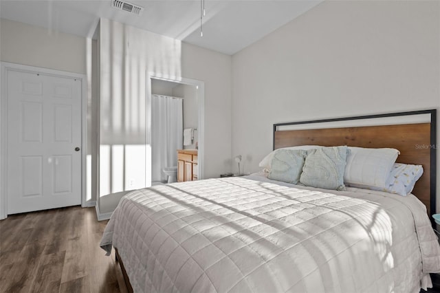 bedroom featuring ensuite bath, wood finished floors, and visible vents