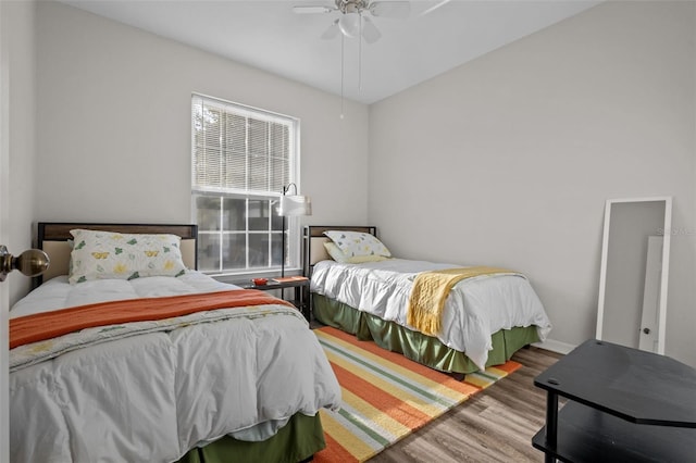 bedroom featuring baseboards, a ceiling fan, and wood finished floors