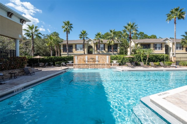 community pool featuring a patio and fence