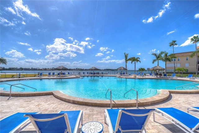 pool with a patio and fence