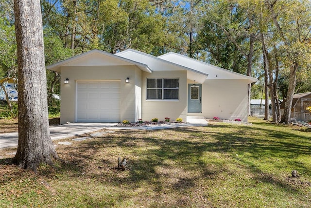 view of front of home with a garage, a front yard, and driveway