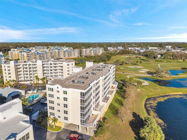 drone / aerial view featuring view of golf course, a water view, and a city view