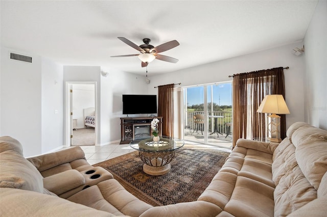 living area featuring baseboards, visible vents, a ceiling fan, and tile patterned floors