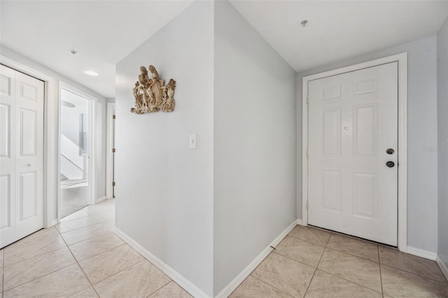 foyer entrance with light tile patterned flooring and baseboards