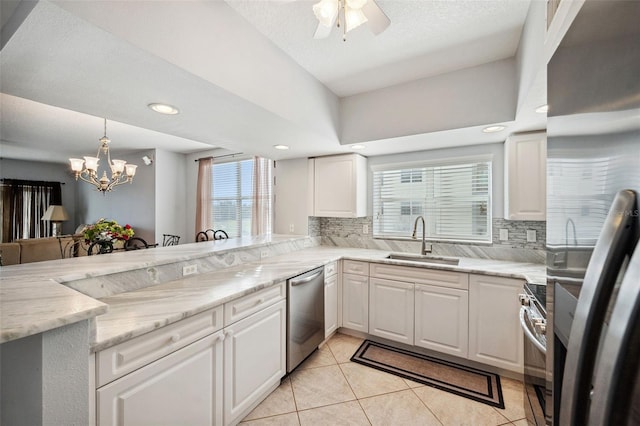 kitchen with stainless steel appliances, light tile patterned flooring, a sink, and a wealth of natural light