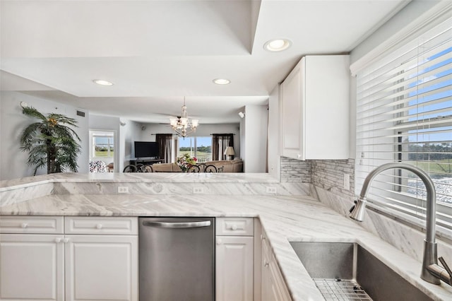 kitchen with white cabinets, a healthy amount of sunlight, a sink, and an inviting chandelier