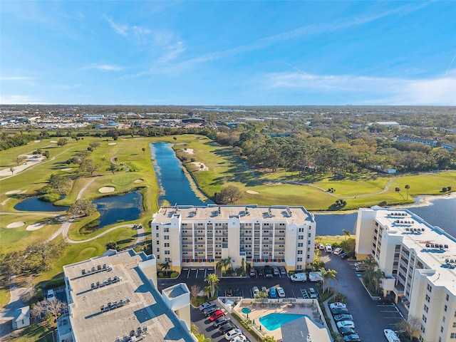 drone / aerial view with golf course view and a water view