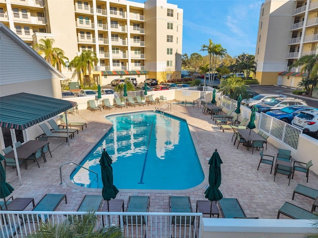 community pool with fence and a patio