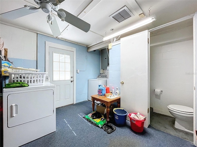 laundry area with concrete block wall, laundry area, visible vents, and washing machine and clothes dryer