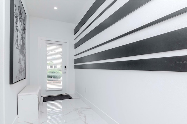 doorway featuring marble finish floor and baseboards