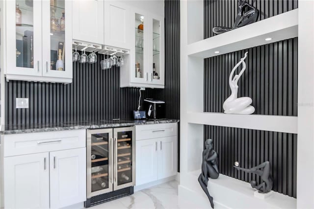 bar with marble finish floor, beverage cooler, and wet bar