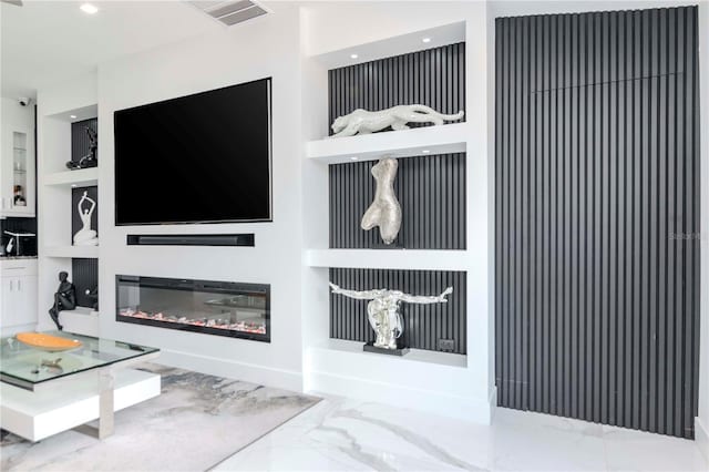 living area featuring visible vents, baseboards, built in features, marble finish floor, and a glass covered fireplace