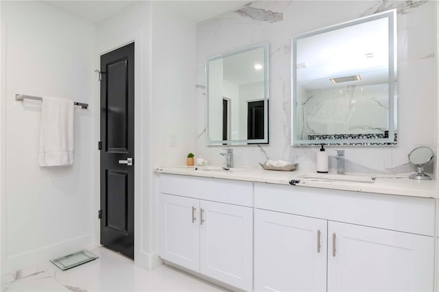 bathroom with marble finish floor, double vanity, a sink, and a marble finish shower