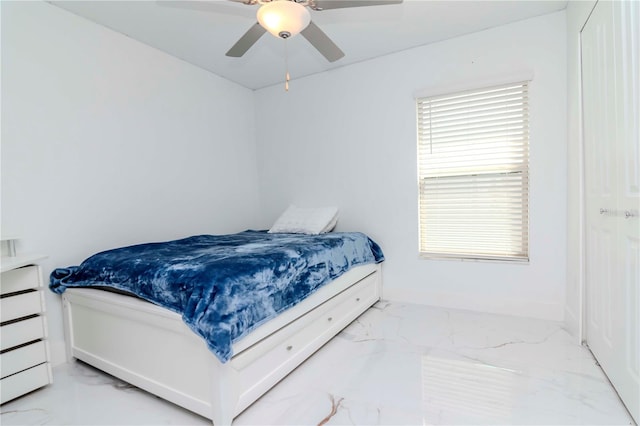 bedroom featuring marble finish floor and a ceiling fan