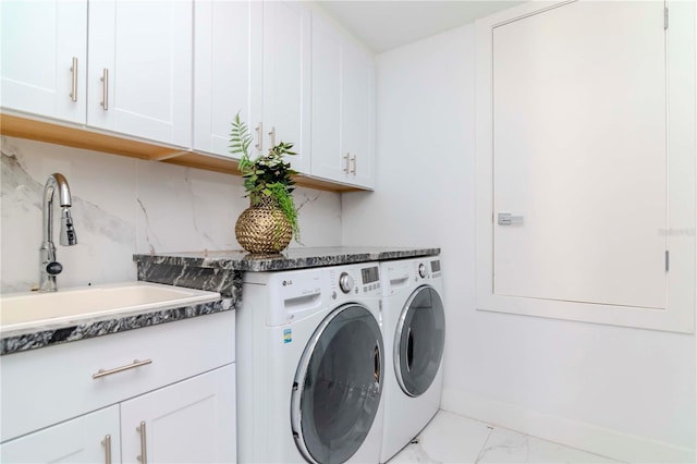 clothes washing area with marble finish floor, cabinet space, a sink, independent washer and dryer, and baseboards