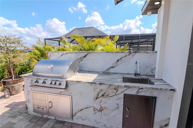 view of patio / terrace with a grill, a sink, and an outdoor kitchen