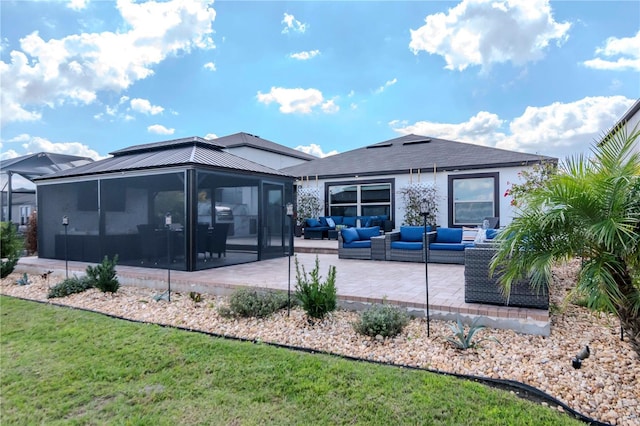 back of house with a patio area, an outdoor living space, a sunroom, and a yard