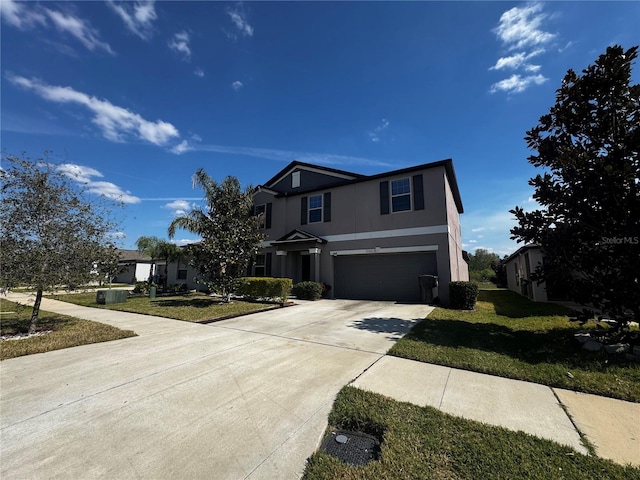 view of front of house with a front yard, driveway, an attached garage, and stucco siding