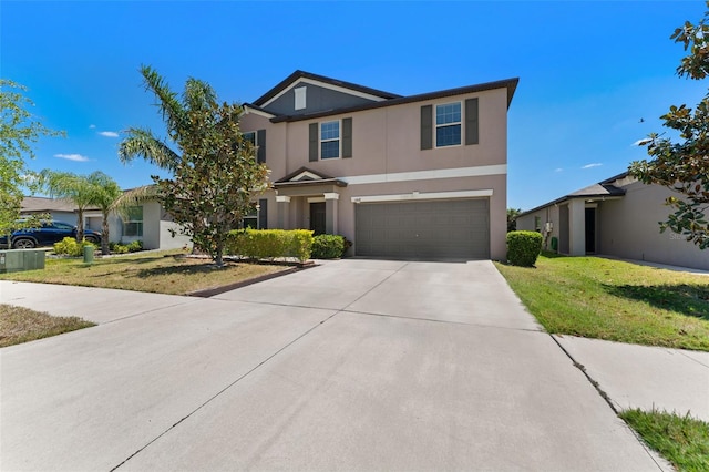 view of front of home featuring a front lawn, an attached garage, concrete driveway, and stucco siding