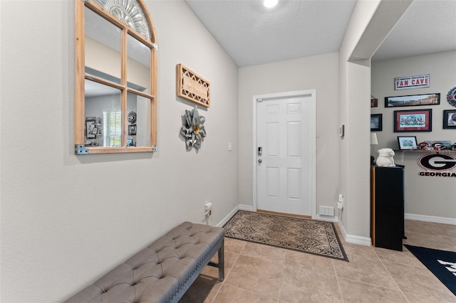 entryway with baseboards and tile patterned flooring