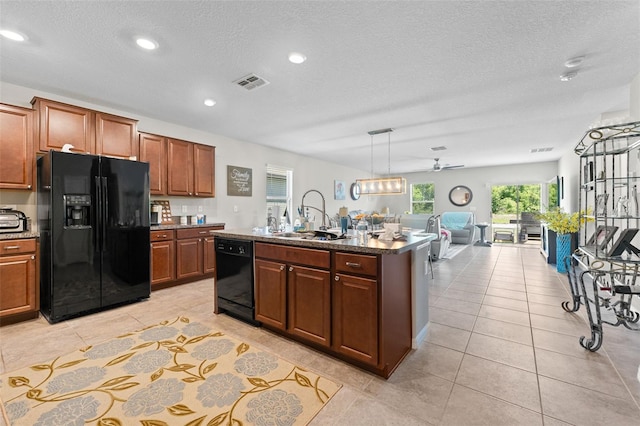 kitchen with visible vents, a sink, black appliances, a textured ceiling, and open floor plan