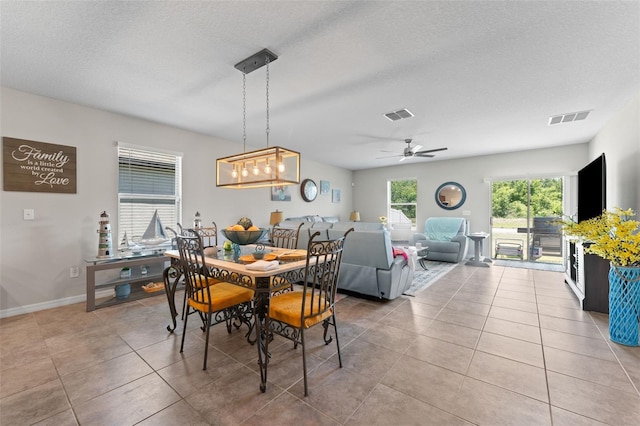 dining space with light tile patterned flooring, visible vents, and ceiling fan