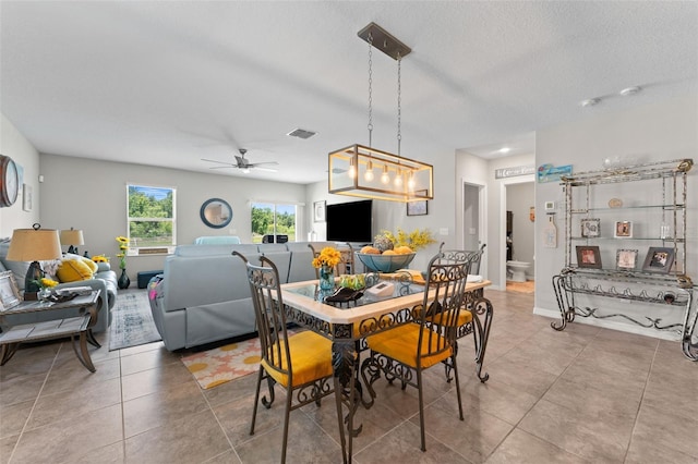 tiled dining room with visible vents, a textured ceiling, and ceiling fan