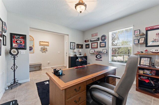 office space featuring baseboards, a textured ceiling, and light tile patterned floors