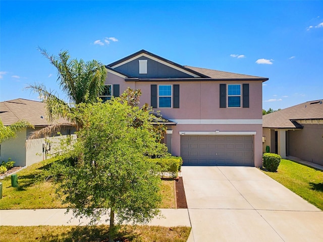 traditional-style home with concrete driveway, an attached garage, and stucco siding