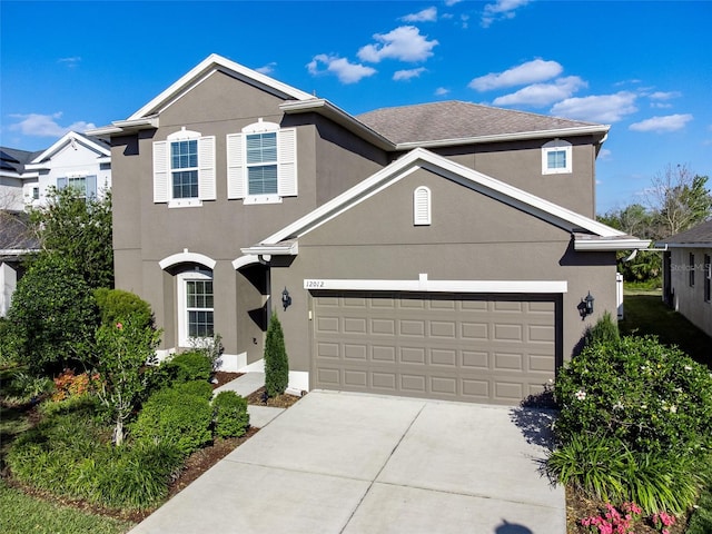 traditional home featuring concrete driveway and stucco siding