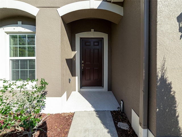 view of exterior entry with stucco siding