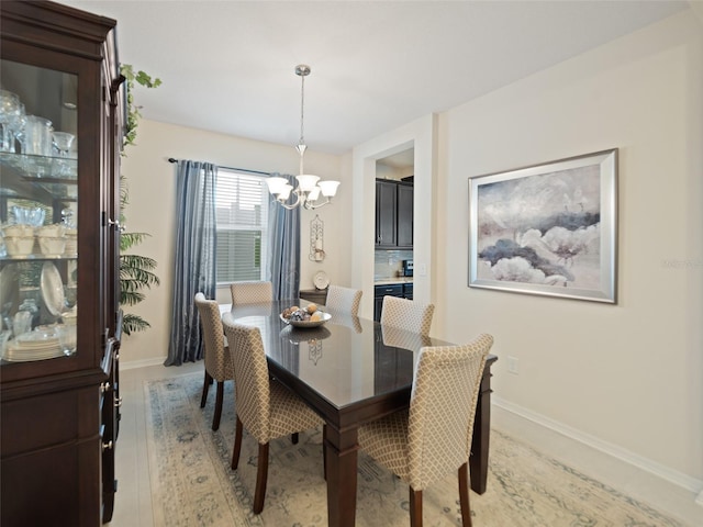 dining room featuring baseboards and an inviting chandelier