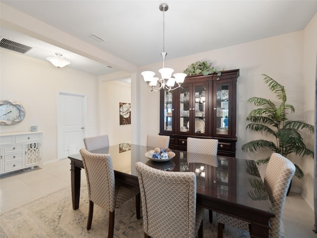 dining space featuring light tile patterned floors, visible vents, and a notable chandelier