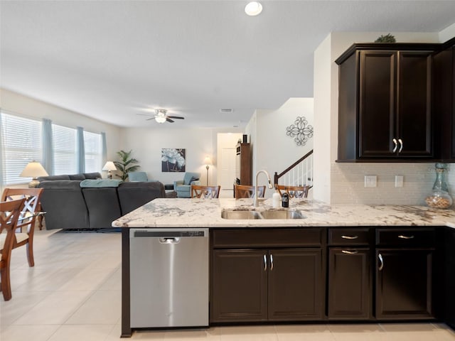 kitchen with tasteful backsplash, dishwasher, a peninsula, light stone countertops, and a sink