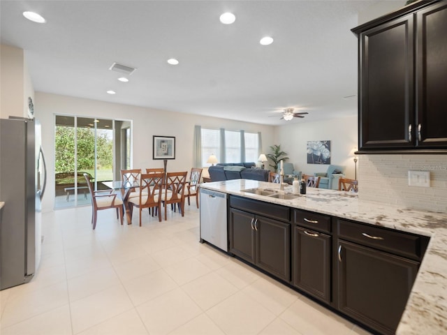 kitchen with stainless steel appliances, visible vents, open floor plan, a sink, and a peninsula