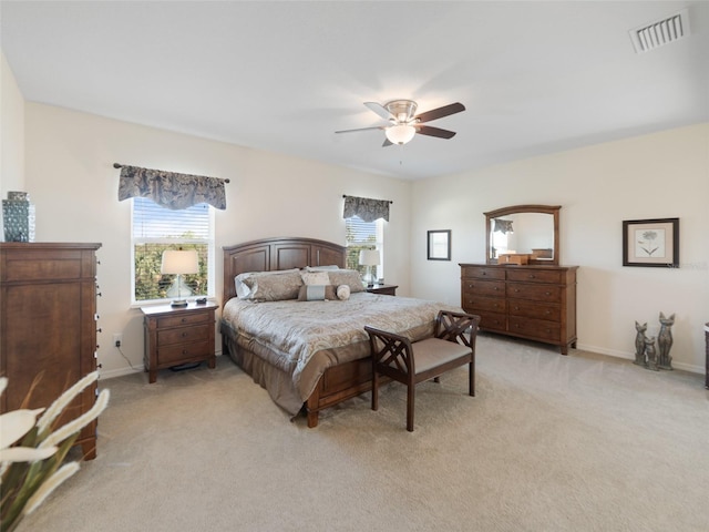 bedroom featuring baseboards, visible vents, and light colored carpet