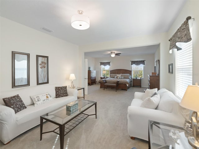 carpeted living area with ceiling fan and visible vents