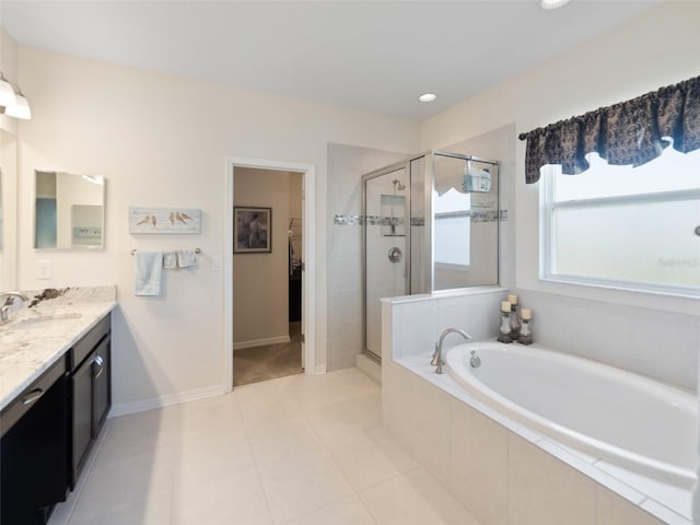 full bath featuring tile patterned flooring, a garden tub, vanity, a stall shower, and a walk in closet