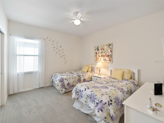 bedroom featuring ceiling fan, baseboards, and light colored carpet