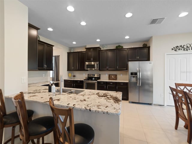 kitchen with recessed lighting, stainless steel appliances, a peninsula, a sink, and visible vents