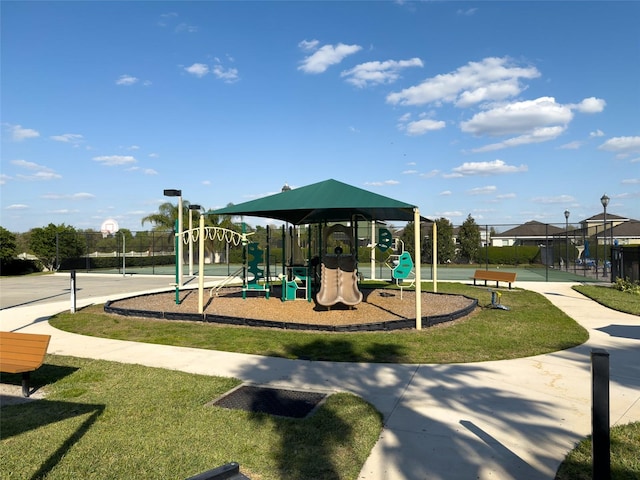 community jungle gym featuring a yard and fence