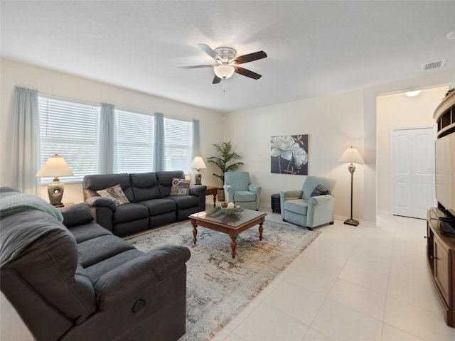 living room featuring visible vents, ceiling fan, baseboards, and light tile patterned floors