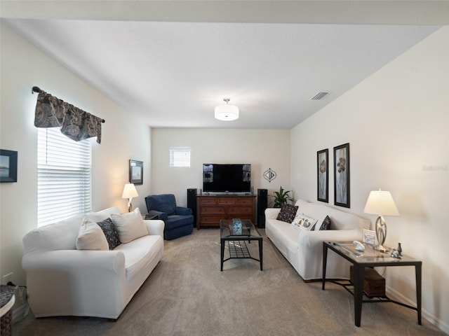 living area featuring visible vents and light colored carpet