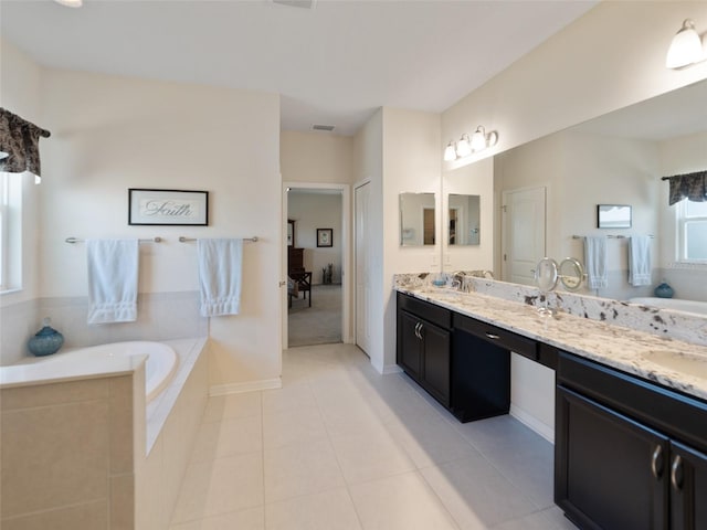 full bathroom featuring a sink, double vanity, tile patterned flooring, and a garden tub